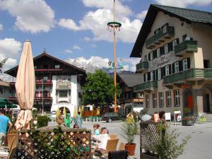 a group of people sitting in chairs in front of a building at Apartement GYARMATY in Sankt Johann in Tirol
