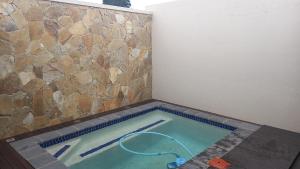a swimming pool in a room with a stone wall at Usambara Lodge in Muldersdrift