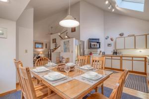 a dining room and kitchen with a wooden table and chairs at Driftwood Cottage MCA 491 - Meredith Lodging in Manzanita