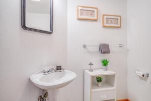 a white bathroom with a sink and a mirror at Driftwood Cottage MCA 491 - Meredith Lodging in Manzanita