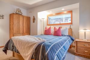 a bedroom with a bed with a blue comforter and a window at Driftwood Cottage MCA 491 - Meredith Lodging in Manzanita