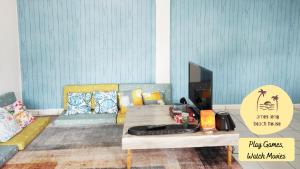 - un salon avec une table et un canapé dans l'établissement Ames Leng Beach House @ PD 5th Mile, à Port Dickson