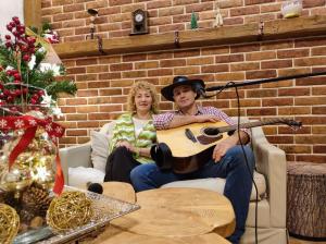 un hombre y una mujer sentados en un sofá tocando la guitarra en Dom Kowala, en Jankowce