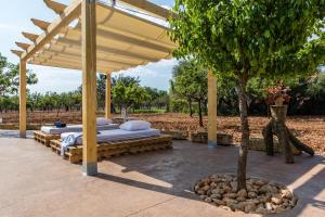 pérgola de madera con 2 camas bajo un árbol en Villa FRARE, en Búger
