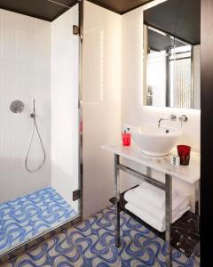 a bathroom with a sink and a shower at Mama Shelter Lisboa in Lisbon