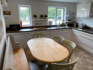 a kitchen with a wooden table and chairs at Coastal View 3 Bed Luxury House in Southwell