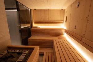 una sauna con bancos de madera y luces en una habitación en Posthotel Valbella, en Valbella