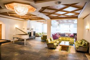 a living room with a piano and couches at Posthotel Valbella in Valbella