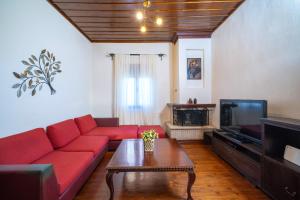 sala de estar con sofá rojo y TV en il giardino, en Skala Kallirakhis