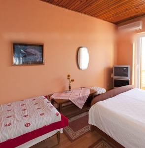 a bedroom with two beds and a table and a tv at Studio apartment in Tucepi with sea view, balcony, air conditioning, WiFi 3674-4 in Tučepi