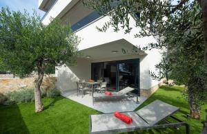 a garden with a table and chairs in a yard at Villa Marija in Sveti Filip i Jakov