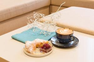 a cup of coffee and a plate of food on a table at Nesterov Plaza Hotel in Ufa