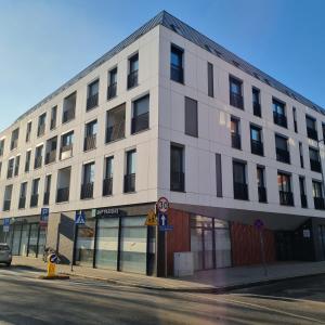 un edificio blanco en la esquina de una calle en Apartament Skarbowa, en Leszno