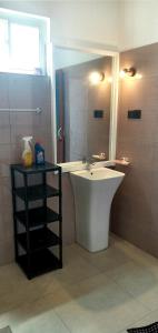 a bathroom with a tub and a sink and a mirror at Coral Reef Guest in Beruwala