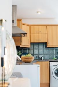 a kitchen with wooden cabinets and a bowl of apples at Tranquil Little Hide-Away in Oxford with Private Garden in Oxford