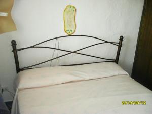 łóżko z czarnym zagłówkiem w pokoju w obiekcie Appartamento Taras Sottovento - Porto Cervo w mieście Abbiadori