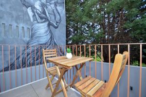 einen Holztisch und zwei Stühle auf dem Balkon in der Unterkunft Oliva Teles 53 Apartments in Arcozelo