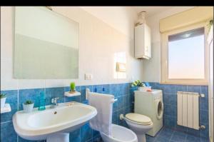 uma casa de banho azul e branca com um lavatório e um WC em Piazza del Sole Apartment em San Salvo
