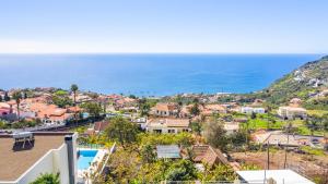 a view of a town with the ocean in the background at Hillside Villa in Arco da Calheta