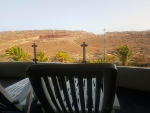 a bench sitting on a balcony with a view of the desert at Apartment Tenerife Sur in Palm-Mar
