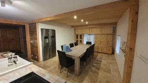 une cuisine et une salle à manger avec une table et des chaises dans l'établissement LA FERME LES DIGITALES bain nordique, billard, à La Bresse
