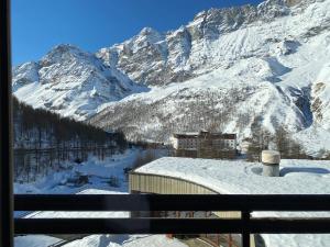 a view of a snow covered mountain from a window at White Escape in Valtournenche