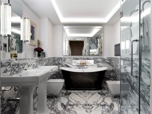 a bathroom with two sinks and a bath tub at Ham Yard Hotel, Firmdale Hotels in London