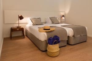 a bedroom with a large bed with a hat on it at bnapartments Cedofeita in Porto +53 photos