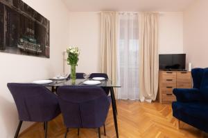 a dining room with a table and blue chairs at City Center Apartment Elektoralna by Renters in Warsaw