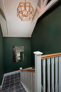 a staircase with a green wall and a mirror at Monks Ballyvaughan in Ballyvaughan