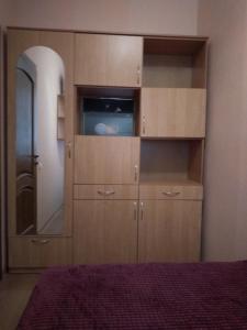 a bedroom with a large wooden cabinet with a mirror at 2-x Apartments Center Wi-Fi около Площади in Chernihiv