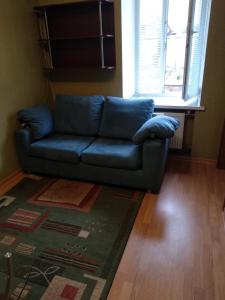 a blue couch in a living room with a rug at 2-x Apartments Center Wi-Fi около Площади in Chernihiv