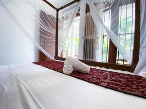 a bedroom with a bed with a pillow and a window at Shirani nature palace Midigama in Weligama
