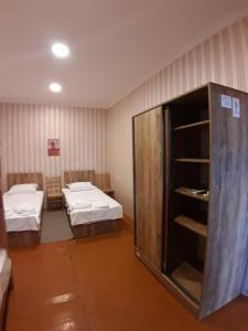 a room with two beds and a cabinet in it at Nargizaanta in Gurjaani