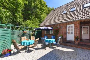 a patio with a table and chairs and an umbrella at Ferienhaus Elfriede Coordes in Moorweg