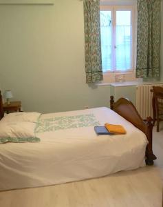 a bed in a bedroom with a window and a book on it at Grand T3 avec cour intérieure in Gray