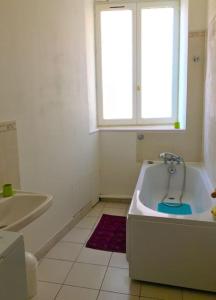 a white bathroom with a tub and a window at Grand T3 avec cour intérieure in Gray