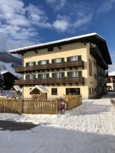 a large building with a wooden fence in the snow at Landhotel Steindlwirt in Dorfgastein
