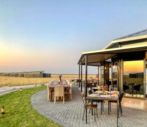 a patio with tables and chairs on the grass at Etosha King Nehale in Omuthiya