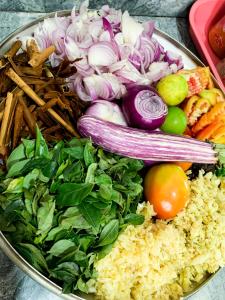 a bowl of food with vegetables on a table at Shirani nature palace Midigama in Weligama +64 photos
