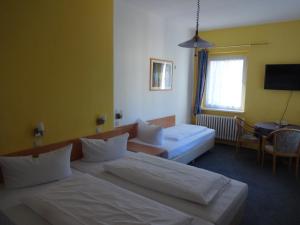 a hotel room with two beds and a tv at Hotel Süden in Berlin