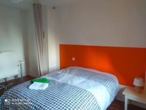 Élégant T4 في Pesmes: غرفة نوم مع سرير مع اللوح الأمامي من البرتقال