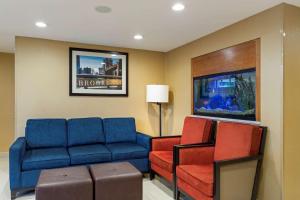 a living room with a blue couch and red chairs at Comfort Inn Brooklyn in Brooklyn
