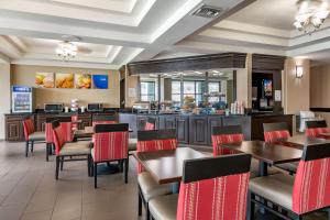 a restaurant with tables and chairs and a counter at Comfort Suites Baymeadows Near Butler Blvd in Jacksonville