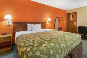 una habitación de hotel con una cama grande y paredes de color naranja en Econo Lodge en Billings