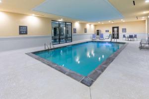 a large pool with blue water in a building at La Quinta Inn & Suites by Wyndham Dallas - Frisco Stadium in Frisco
