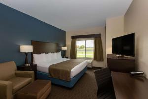 スーフォールズにあるAmericInn by Wyndham Sioux Falls Northのベッドとテレビが備わるホテルルームです。
