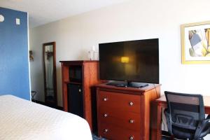 a bedroom with a bed and a flat screen tv at Baymont by Wyndham Dayton North in Dayton