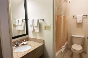 a bathroom with a sink and a toilet and a mirror at Baymont by Wyndham Dayton North in Dayton