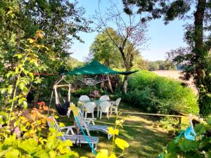 a garden with chairs and a swing at Naturellement Loire ! in Saint-Martin-de-la-Place